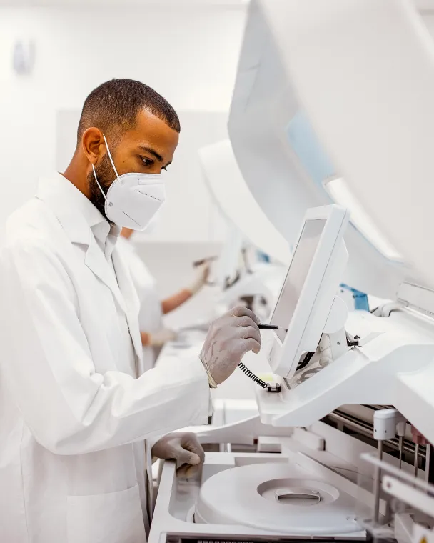 A masked scientist works over his experiment station