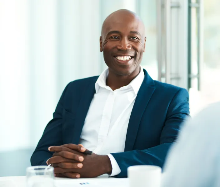 An employee smiles at a colleague in a meeting