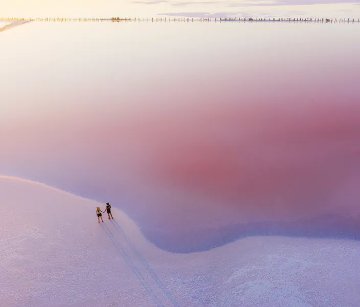 Scenic aerial view of peoppe walking on pink salt lake