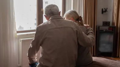 Contemplative senior couple sits on a bed