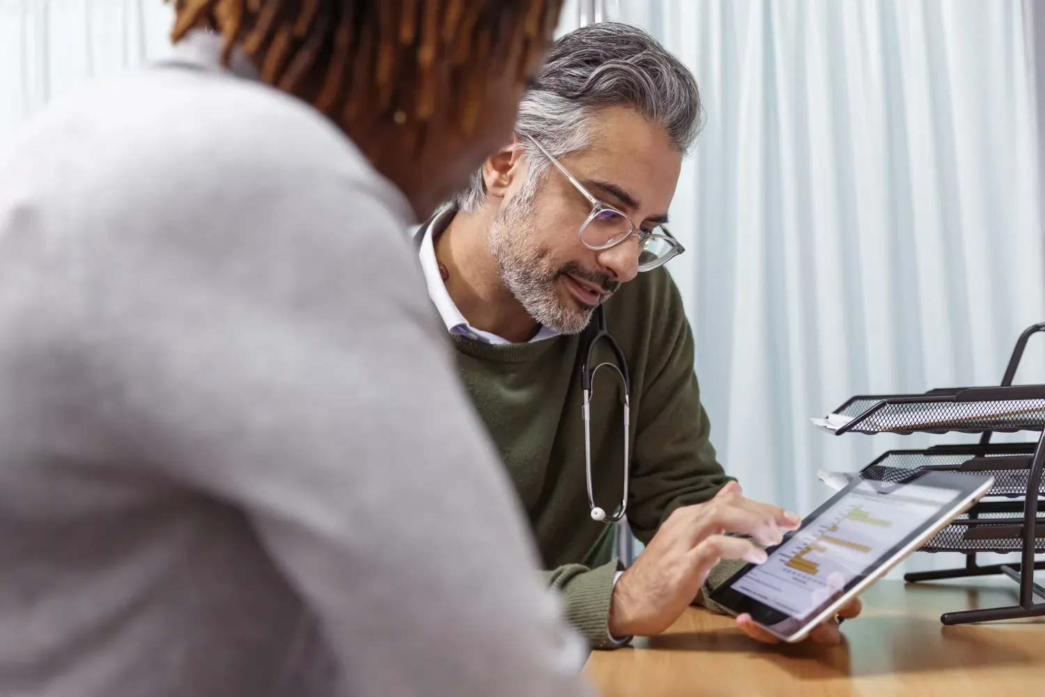 Two colleagues discuss work over a tablet