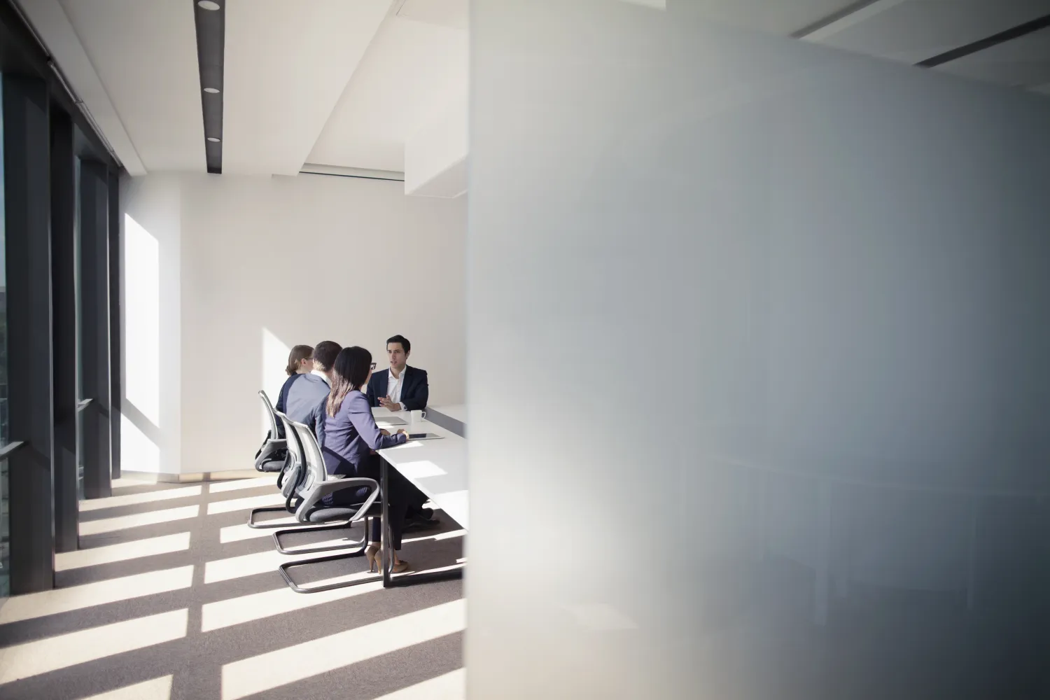 Work colleagues converse in a meeting room