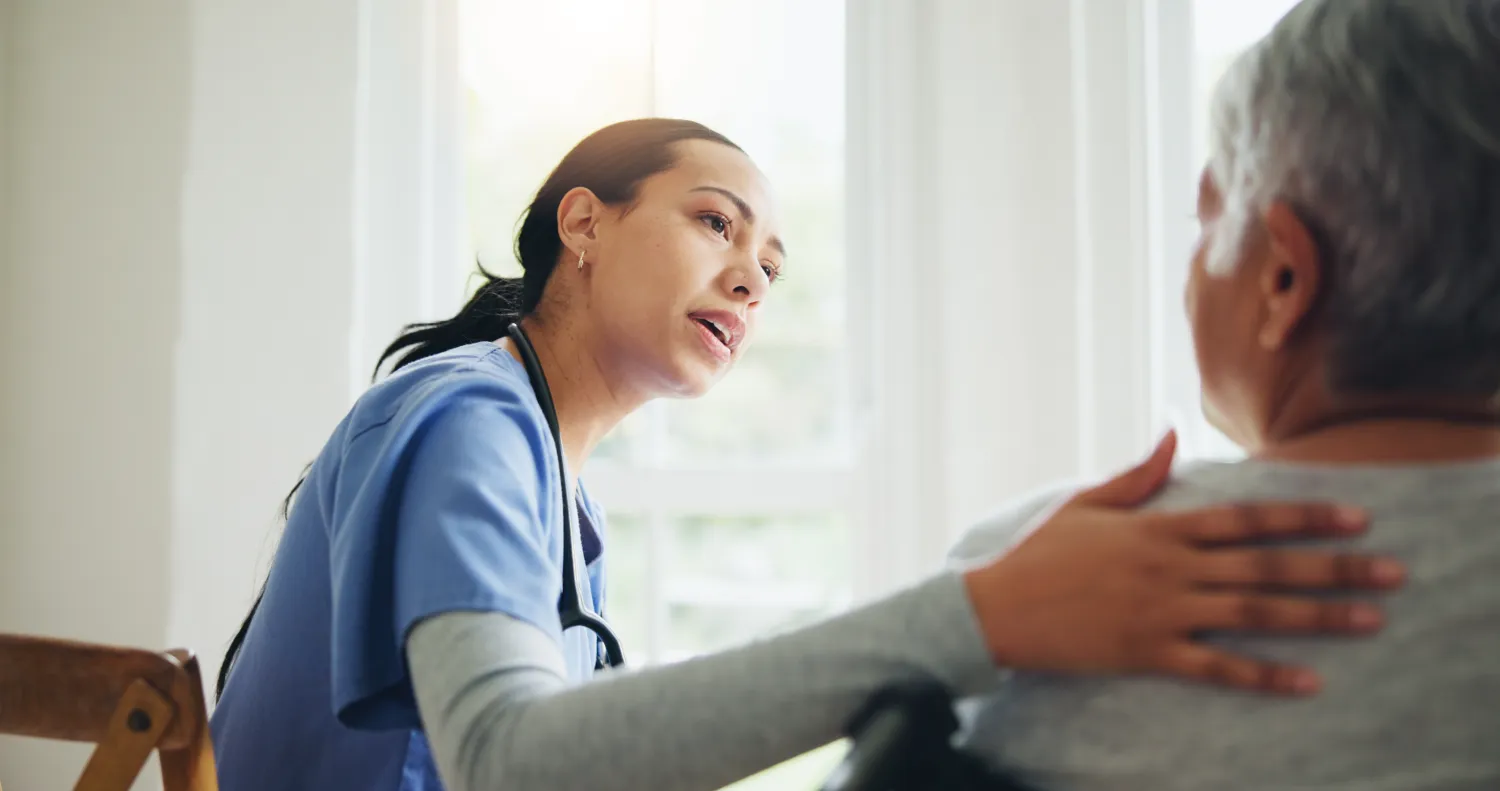 Nurse and senior in wheelchair discussing diagnosis