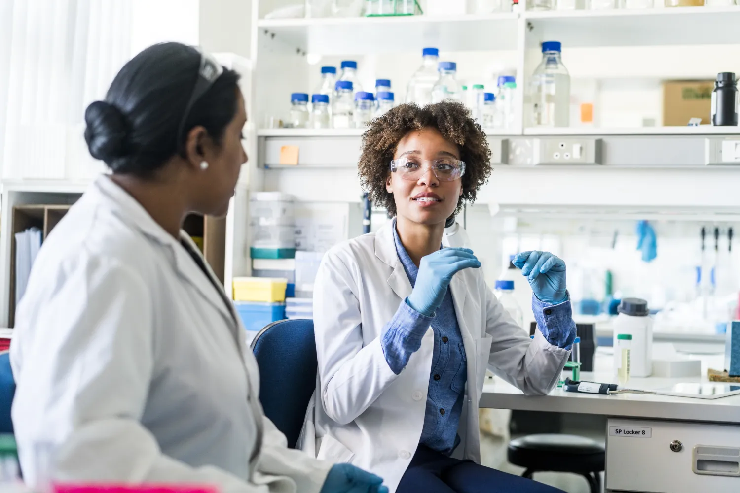 Two scientists discuss in a lab setting