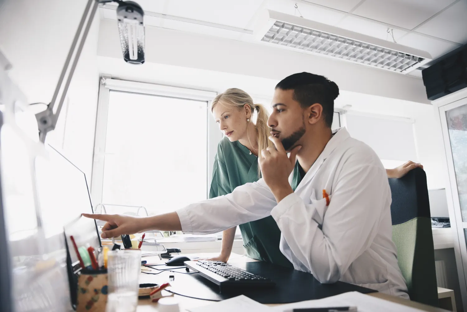 Two healthcare workers looking at a screen intently.